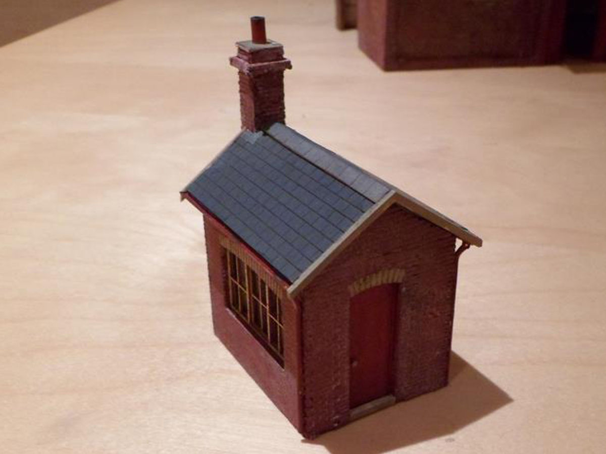 "First attempt -  For a station layout of Masham (Yorkshire), being modelled with buildings as per original in 1930. Weighbridge office, built from the kit but adapted as per prototype with external chimney with distinctive decor strip, no window next to door and detailing. Finished in North Eastern Railway colours, which it was probably still in at that time."