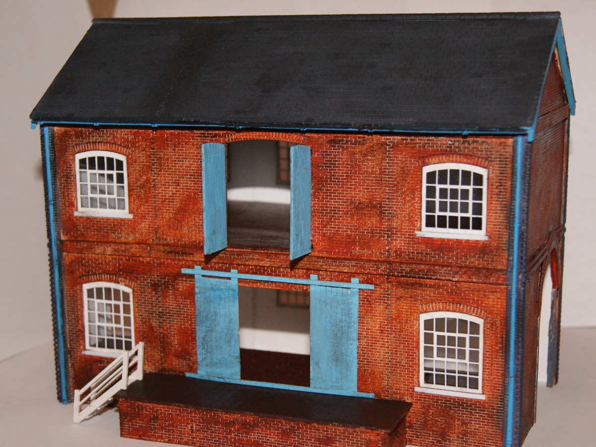B 00-16 lineside warehouse painted and assembled by Claire and Martin. A very interesting modification of the two railways entrances allowing goods to be unloaded from the inside of the warehouse.