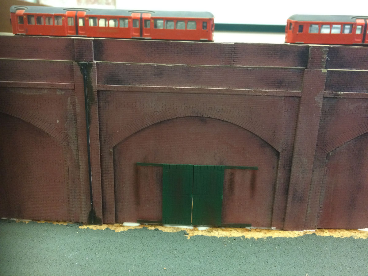 "A length of railway arches being test fitted to a club layout. Painted with car primer spray, watered-down colour testers, weathering powders and washes."