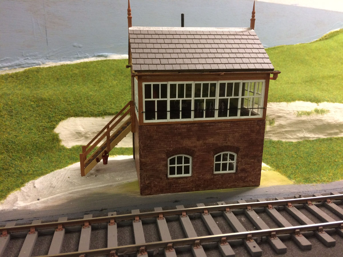 "Built for the Mere & District's new O gauge layout "Mere Abbas". The signal box has Scalelink gutters and finials plus York Model's tiles added. The station building has been modified to a hipped roof and replacement chimney stacks have been scratch built. Tiles and gutters are as the signal box. The station awning has "lead rolls" added to create more detail."